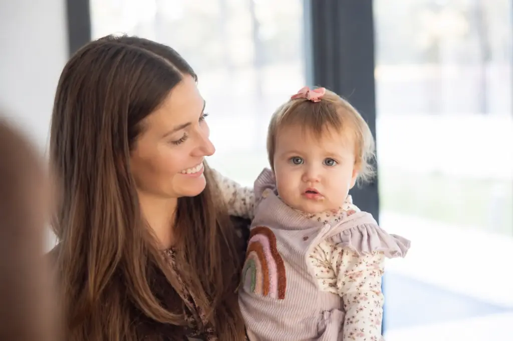Una madre sostiene a su hija durante una comida familiar