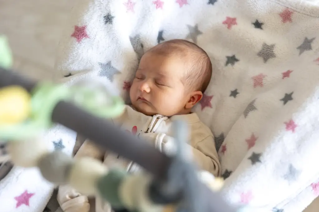 Bebé recién nacido durmiendo en una superficie despejada.